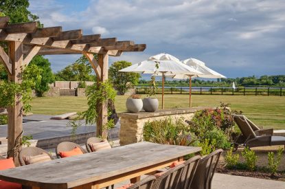 The outdoor dining table and countryside views at Lakeside Manor, Cotswolds
