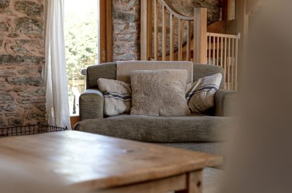 A sofa in the living room with a coffee table at Chapel Cottage, Pembrokeshire
