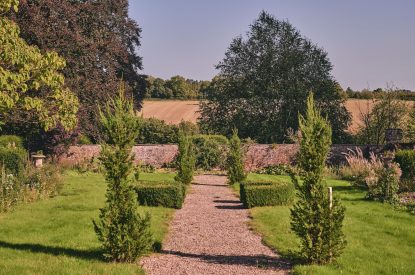 A stone path leading through the gardens at Kingfisher Cottage, Welsh Borders