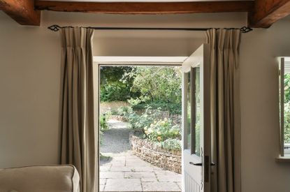 The front door with views to the stone pathway at Rambling Rose Cottage, Cotswolds