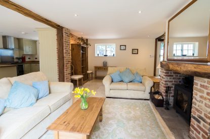 The living room with two sofas facing the log burner at Brightwaters Stables, Hampshire