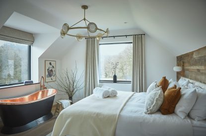A super king size bedroom with Copper bath at Copeland House, Lake District