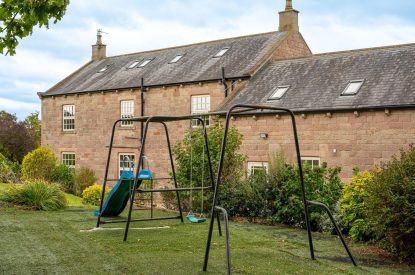 The children's play area with a slide and swing set at Tinkers Folly, Yorkshire