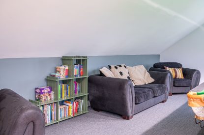 The sofas and books in the games room at Tinkers Folly, Yorkshire