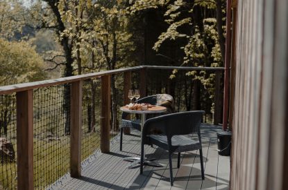 Two chairs and a table on the balcony overlooking the countryside at Ermine, Scotland