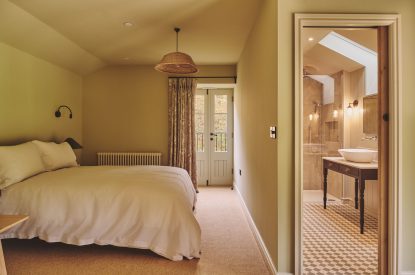 A king-size bedroom with en-suite bathroom at Haymill Retreat, Powys