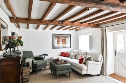 The cosy living room with a sofa and armchair at Rambling Rose Cottage, Cotswolds