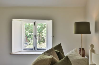 The window with pretty views in the master bedroom at Rambling Rose Cottage, Cotswolds