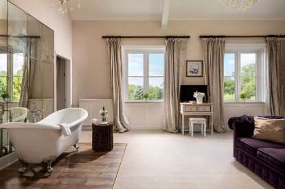 A king-size bedroom with roll-top bath at The Victorian Manor, Dorset