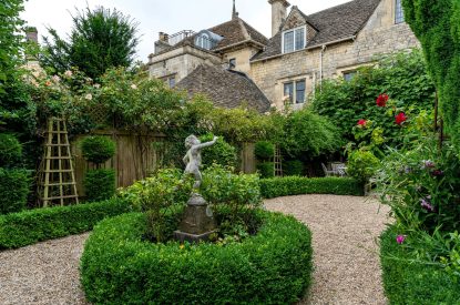 The plinthed statue in the private rose garden at Wild Rose Cottage, Cotswolds
