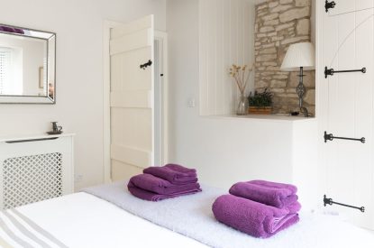 Fluffy towels on the queen-size bed at Wild Rose Cottage, Cotswolds