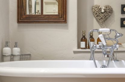 The free-standing bath with luxury toiletries at Wild Rose Cottage, Cotswolds